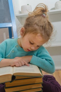 Kız, çocuk, ilkokul öğrencisi bir kitapla