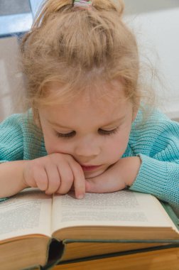 Kız, çocuk, ilkokul öğrencisi bir kitapla