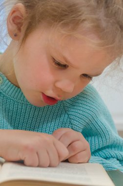 Kız, çocuk, ilkokul öğrencisi bir kitapla