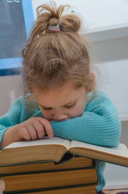 Kız, çocuk, ilkokul öğrencisi bir kitapla