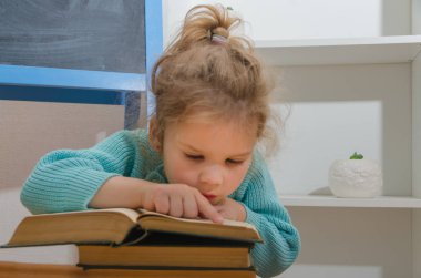 Kız, çocuk, ilkokul öğrencisi bir kitapla