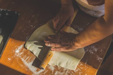 kadının elleri yoğrulur ve güneş ışığında pasta için hamur rulo