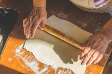 kadının elleri yoğrulur ve güneş ışığında pasta için hamur rulo