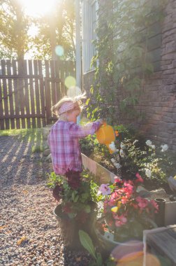 Kız, bir çocuk ile bir Çiçeklik sulama güneşli bir günde bir sulama olabilir