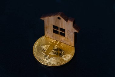 oyuncak ahşap ev ve siyah arka plan üzerine bitcoin