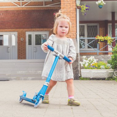Güneşli yaz günü bir kız ve bir çocuk scooter üzerinde
