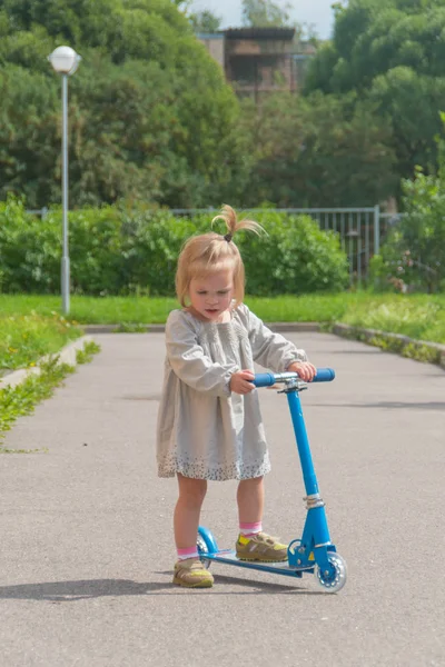 Güneşli yaz günü bir kız ve bir çocuk scooter üzerinde