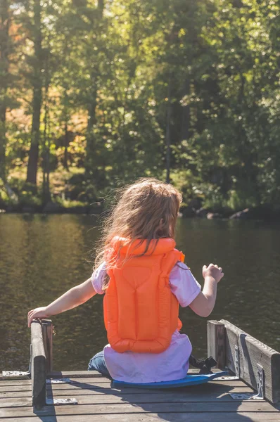 Ragazza Bambino Giubbotto Salvataggio Seduto Sul Molo — Foto Stock