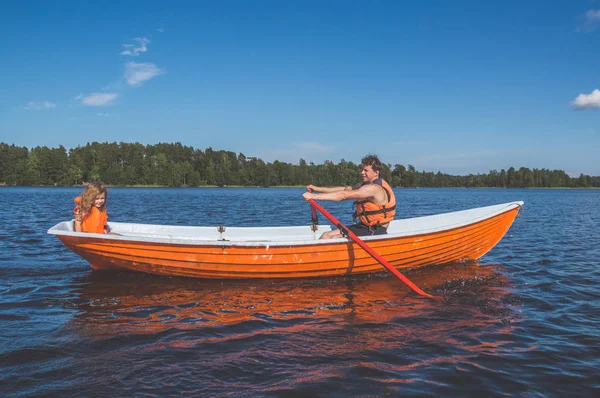 the man and the child, the girl in the boat, rowing on the lake