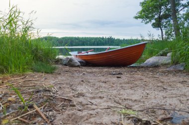 üzerinde kıyıya yakın yerde sazlık ve balıkçı kürek teknesi kayalar