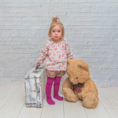 Kız, Çocuk ayı ve Bavula beyaz tuğla ile arka plan duvar