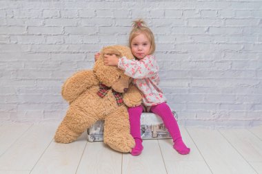 Kız, Çocuk ayı ve Bavula beyaz tuğla ile arka plan duvar