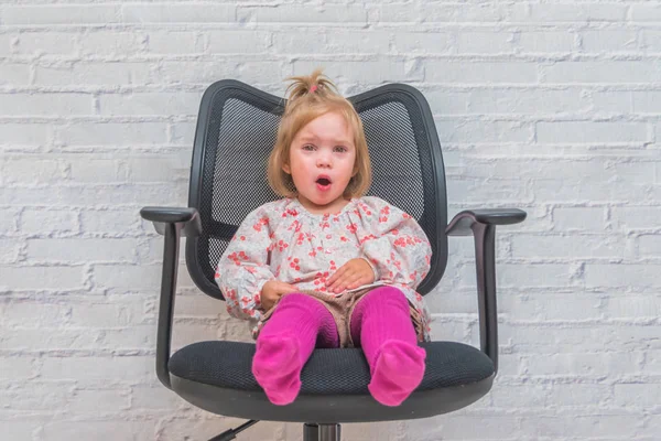 Dívka Dítě Sedět Kancelářské Židli Peřinku Zeď Pozadí Šedivá — Stock fotografie