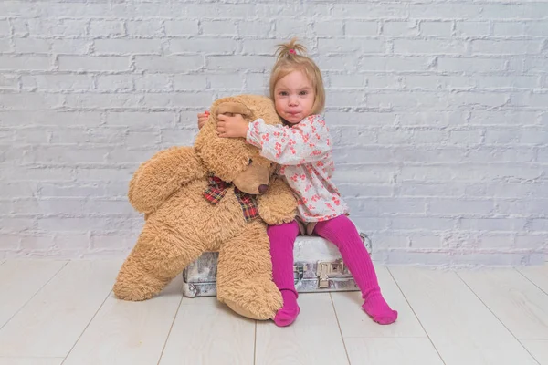 Kız, Çocuk ayı ve Bavula beyaz tuğla ile arka plan duvar