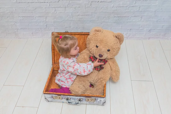 Kız, Çocuk ayı ve Bavula beyaz tuğla ile arka plan duvar