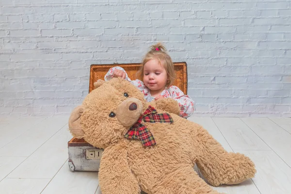 Kız, Çocuk ayı ve Bavula beyaz tuğla ile arka plan duvar