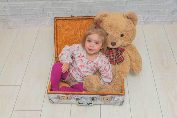 Kız, Çocuk ayı ve Bavula beyaz tuğla ile arka plan duvar