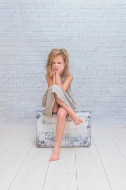 Kız, bebek elbise beyaz tuğla duvar arka çanta