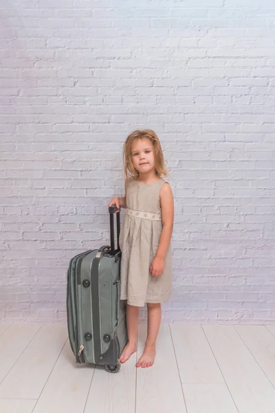 婴儿穿着白色砖墙背景与手提箱 — 图库照片