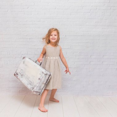 Kız, çocuk çanta beyaz tuğla duvar arka plan üzerinde