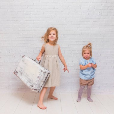 Kız, çocuk çanta beyaz tuğla duvar arka plan üzerinde