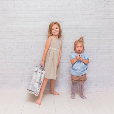 Kız, çocuk çanta beyaz tuğla duvar arka plan üzerinde