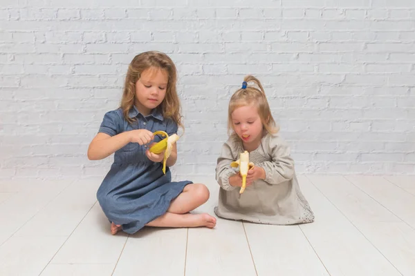 Niña Niño Para Comer Plátano Delicioso Saludable Contra Una Pared — Foto de Stock