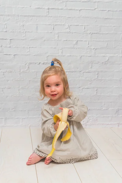 Meisje Een Kind Eten Heerlijke Gezonde Banaan Tegen Een Bakstenen — Stockfoto