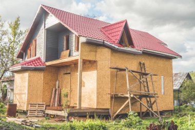 Yaz aylarında çerçeve ahşap ev kazık Bankası ve metal kiremit, çatıdan duvarlar boyalı astar ve bir tabak