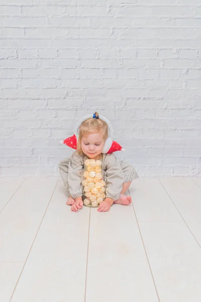 Una Chica Niño Sentado Suelo Con Una Guirnalda Auriculares Navidad — Foto de Stock