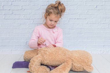 Çocuk, bir kızı bir atış yapan oyuncak ayı, insülin enjektörü