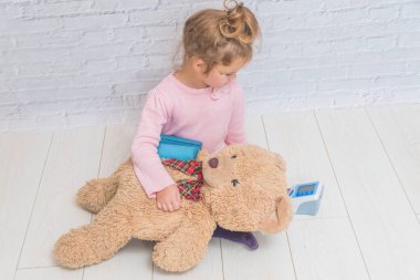 Kız, Doktor, oynayan bir çocuk bir ayı oyuncak basınç ölçer