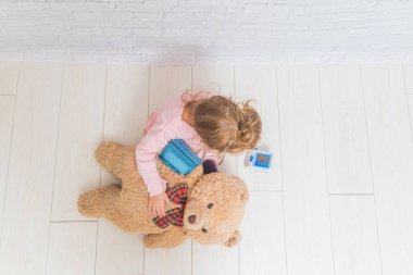 bir kız, Doktor, oynayan bir çocuk bir ayının basınç ölçer 