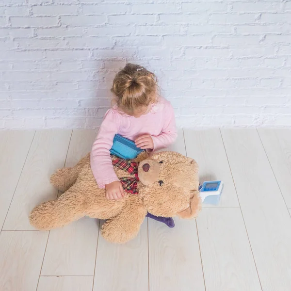 Девочка Играющая Доктора Измеряет Давление Медвежьей Игрушки — стоковое фото