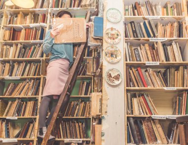 Rusya, St. Petersburg, 3 Kasım, 2018-kız kütüphanede çeker bir kitap raf.