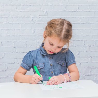 Çocuk, tablo yazar, bir kıza bir parça kağıda beyaz duvara karşı çizer