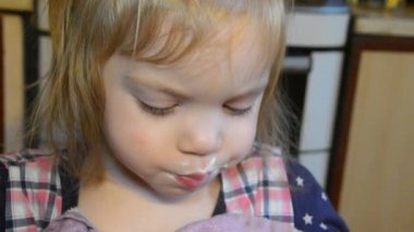 Çocuk, kız bir kaşıkla yemek yiyen bir tabak çorba ve ağzını bir kağıt peçete ile mendil