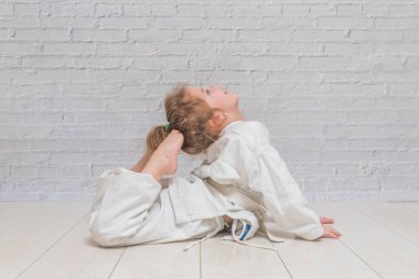 Kız, bir çocuk bir kimono karate eğitim, darbeler ve tebrik çalışır