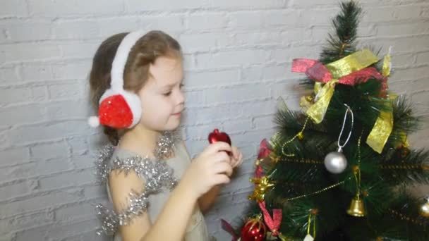 Una Niña Niño Decora Árbol Navidad Sobre Fondo Pared Ladrillo — Vídeos de Stock