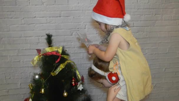 Una Niña Niño Decora Árbol Navidad Sobre Fondo Pared Ladrillo — Vídeos de Stock