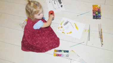 Kız, boya ve fırça katta oturan çocuk boyalar