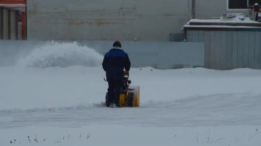 bir çalışan kar özel bir makine ile temizler.