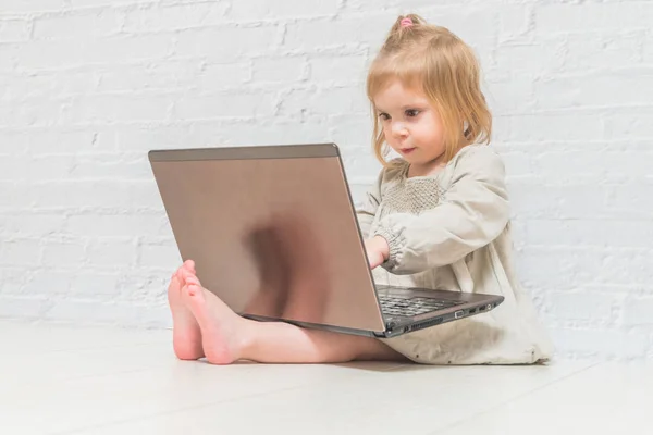 Meisje Kind Zakenvrouw Werken Een Laptop Tegen Een Witte Muur — Stockfoto