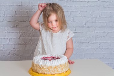 Beyaz tuğla duvar arka plan üzerinde pasta yemeye çocuklar