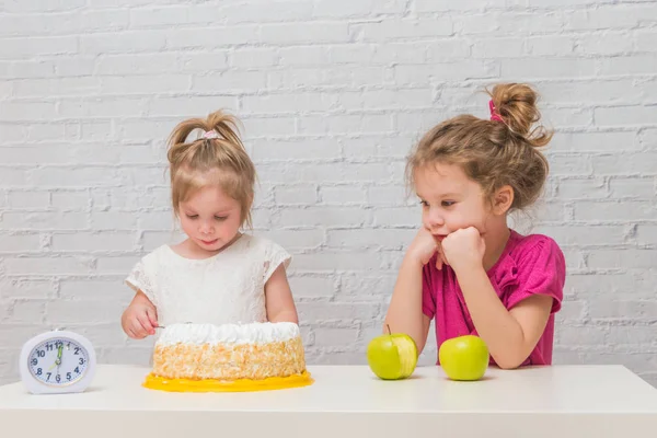 Gesunde Ernährung und Fettleibigkeit, Mädchen, Kinder essen Kuchen und Äpfel, — Stockfoto