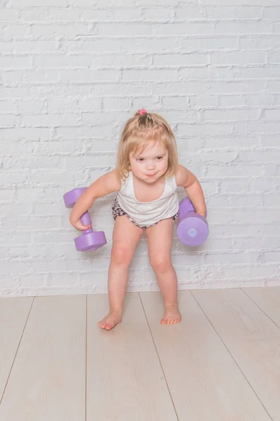 Kız, çocuğu meşgul Fitness dumbbells ile karşı bir — Stok fotoğraf