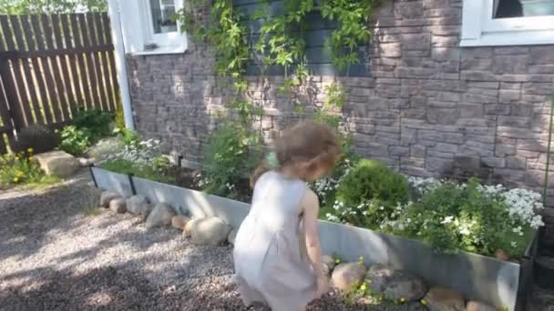 La muchacha veraniega con la regadera regando las flores — Vídeos de Stock