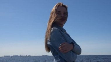 şehirde sahilde güzel kız güneşli bir günde yürüyor