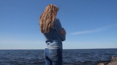 şehirde sahilde güzel kız güneşli bir günde yürüyor
