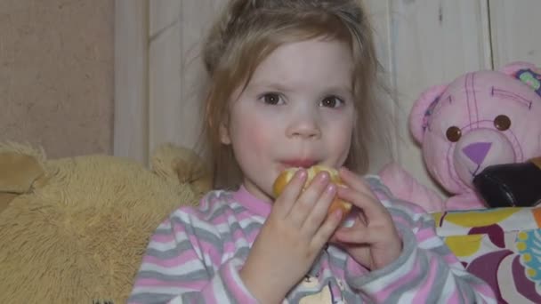 Дівчинка їсть свіже яблуко, наповнене вітамінами — стокове відео